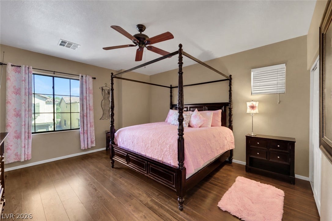 Primary suite bedroom with walk in closet and attached primary suite bath. (AI used to remove items from space).