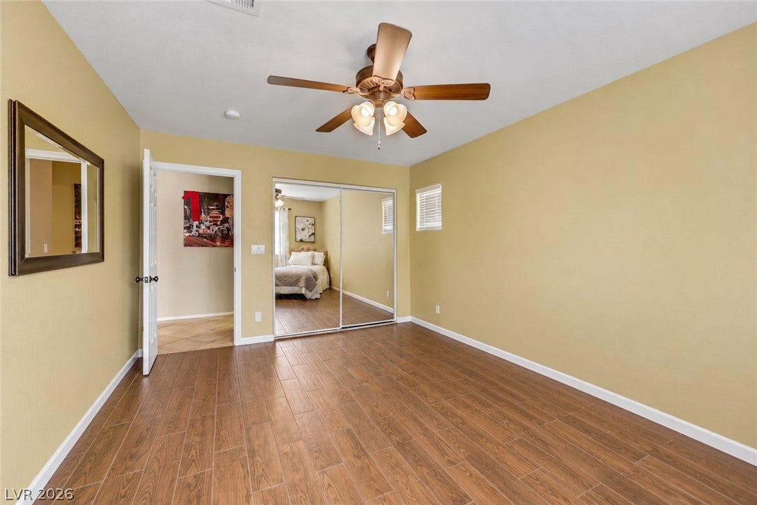 First story bedroom has wall closet with mirror, ceiling fan and ceiling light. (AI used to remove items from space).
