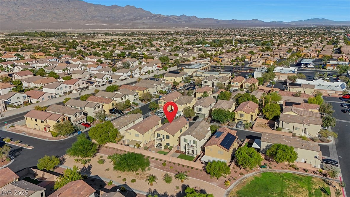 Distant mountains frame a sprawling suburban neighborhood of multi-level homes.