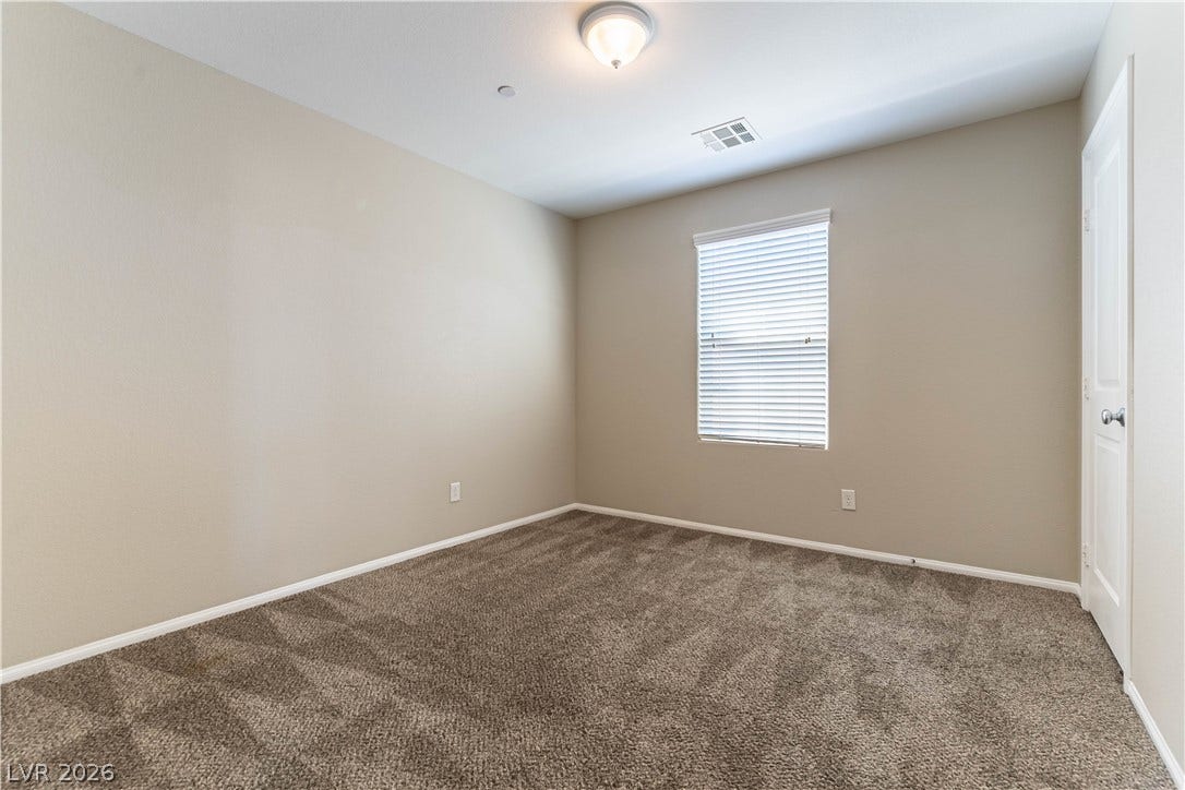 891 Harbor Avenue, Henderson, NV 89002 Plush carpeting and a classic sash window anchor this versatile, neutral-toned room.