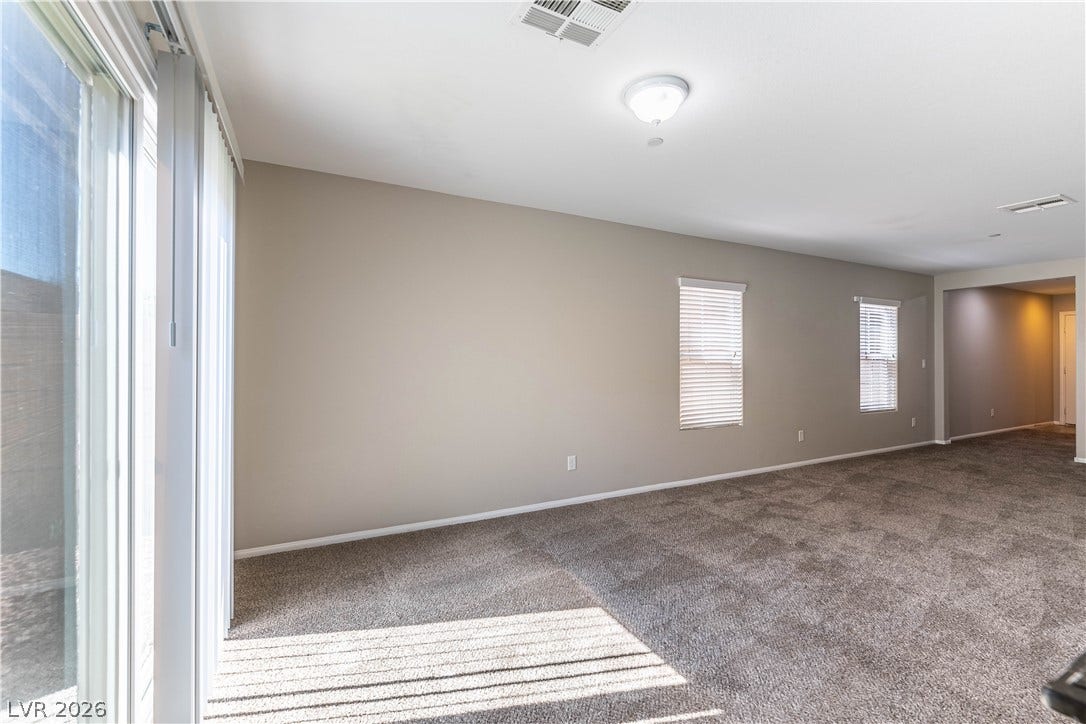 891 Harbor Avenue, Henderson, NV 89002 A spacious carpeted living area features glass sliding doors and multiple windows.