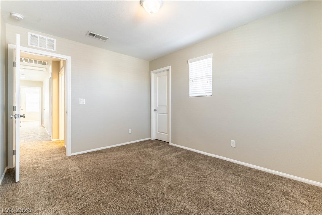 891 Harbor Avenue, Henderson, NV 89002 Soft carpeting underfoot anchors this quiet bedroom filled with natural light.