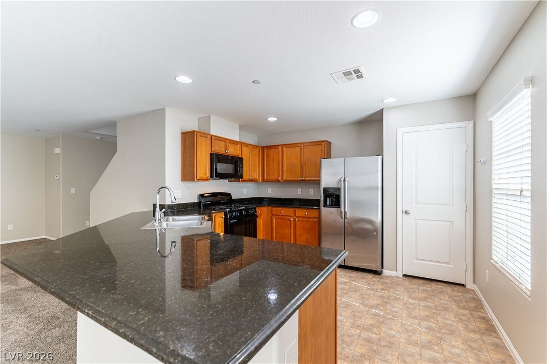 891 Harbor Avenue, Henderson, NV 89002 Polished stone counters and classic wood cabinetry define this functional, open culinary space.