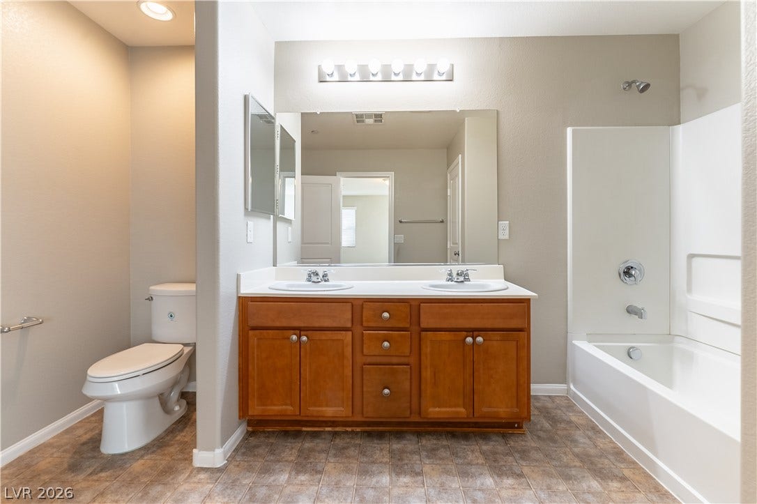 891 Harbor Avenue, Henderson, NV 89002 A spacious double vanity and integrated tub shower define this functional bathroom layout.