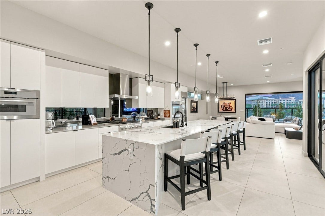 18 Heron Harbour Drive, Henderson, NV 89011 Clean lines and a massive stone waterfall island anchor this open-concept kitchen.