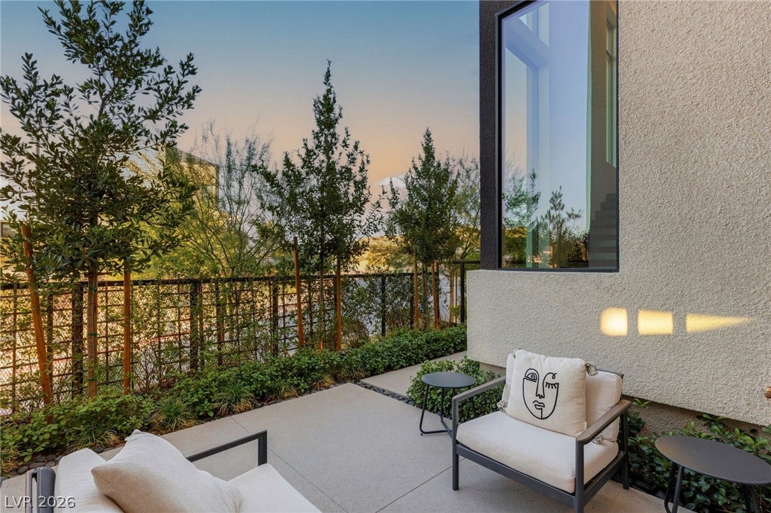 18 Heron Harbour Drive, Henderson, NV 89011 Modern outdoor terrace features concrete paving alongside professional perimeter landscaping.