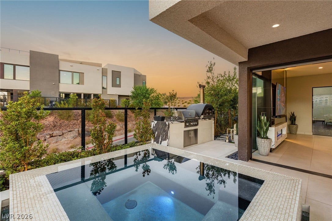 18 Heron Harbour Drive, Henderson, NV 89011 An inviting outdoor spa sits adjacent to a sleek built-in kitchen area on the patio.