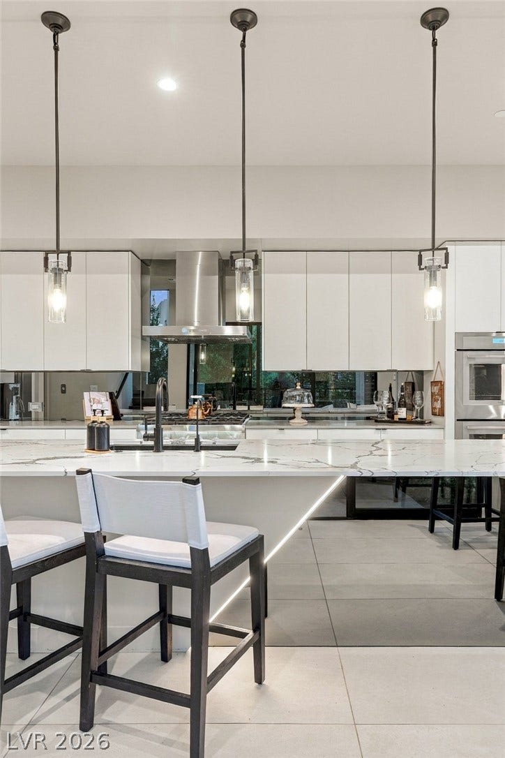 18 Heron Harbour Drive, Henderson, NV 89011 Streamlined cabinetry and premium stone counters define this modern workspace.