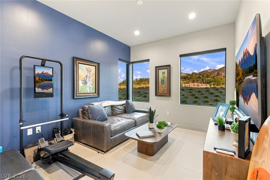 18 Heron Harbour Drive, Henderson, NV 89011 Large picture windows frame serene hillside views in this versatile modern living space.