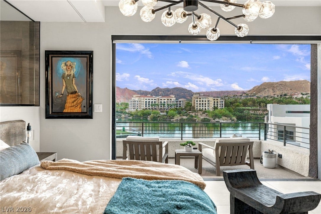 18 Heron Harbour Drive, Henderson, NV 89011 Massive sliding doors open to a private balcony overlooking serene water and mountain views.