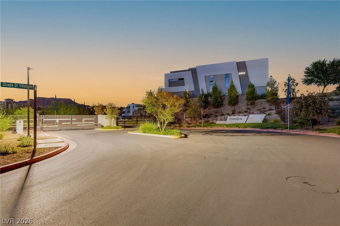 18 Heron Harbour Drive, Henderson, NV 89011 Modern architecture welcomes arrivals at this gated neighborhood entrance under soft sunset skies.