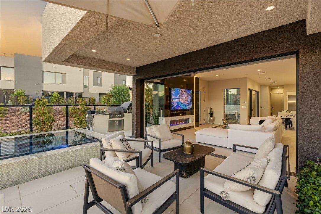 18 Heron Harbour Drive, Henderson, NV 89011 Retractable glass doors connect seamless indoor living spaces with a covered modern terrace.