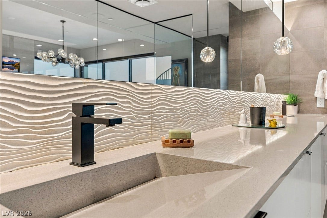 18 Heron Harbour Drive, Henderson, NV 89011 Modern textured tile accents a sleek, integrated sink vanity with clean architectural lines.