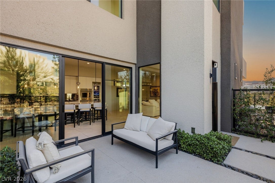 18 Heron Harbour Drive, Henderson, NV 89011 Sleek sliding glass doors seamlessly connect this modern stone patio to the open-concept interior.