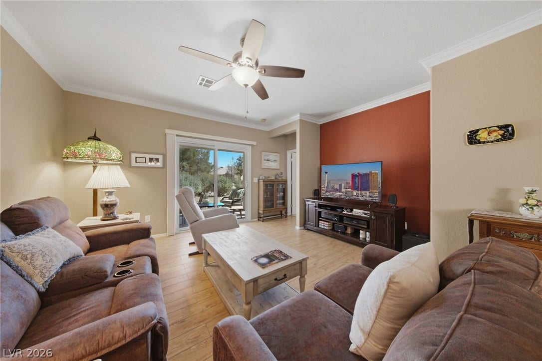7340 Shelduck Street, North Las Vegas, NV 89084 Crown molding and wood-look flooring enhance this welcoming living area leading to the patio.