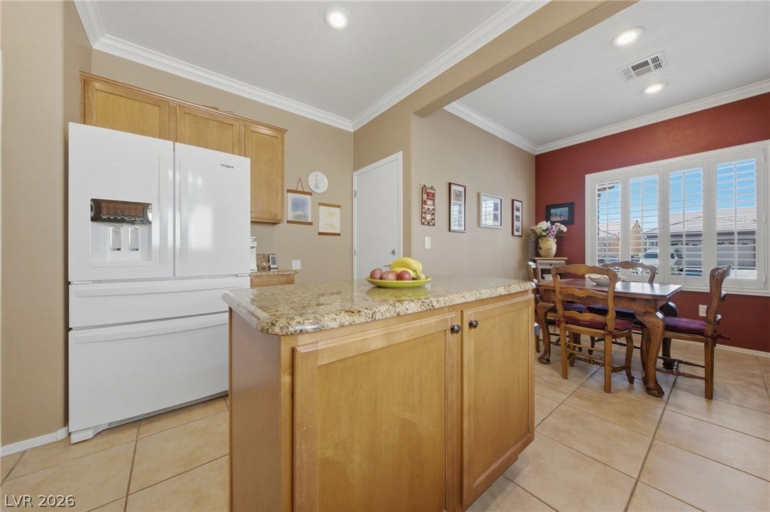 7340 Shelduck Street, North Las Vegas, NV 89084 A spacious layout showcases a central prep island under recessed lighting and crown molding.