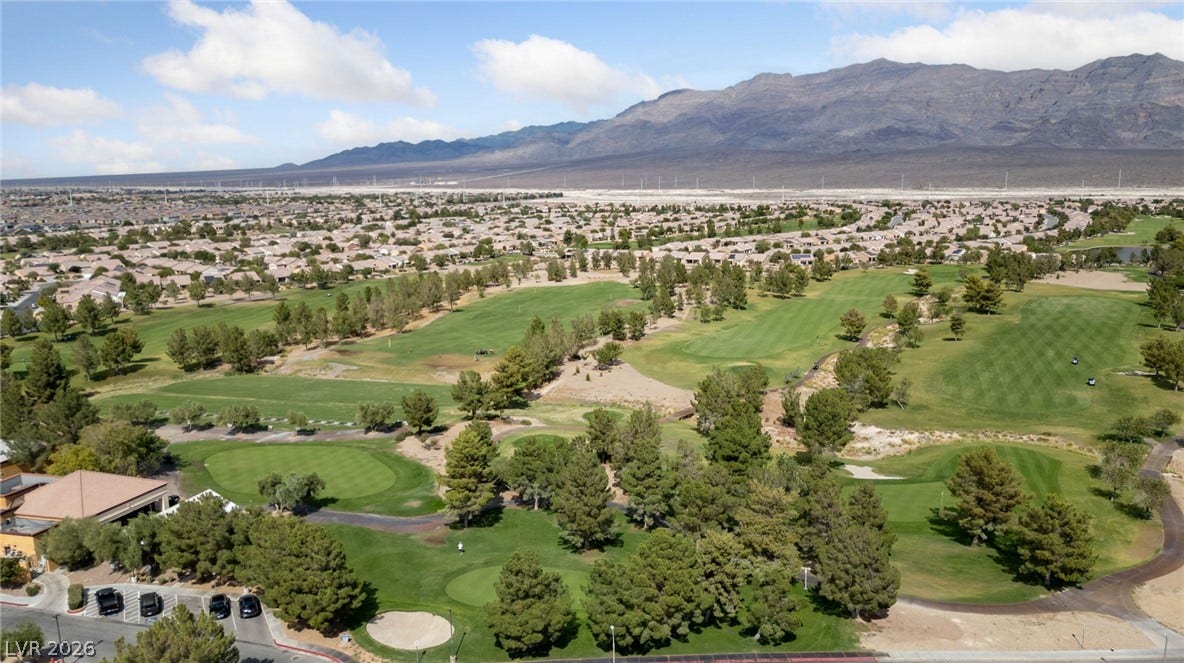 7340 Shelduck Street, North Las Vegas, NV 89084 A sweeping aerial view of Sun City Aliante Golf Course reveals a lush golf course set against a dramatic mountain backdrop.