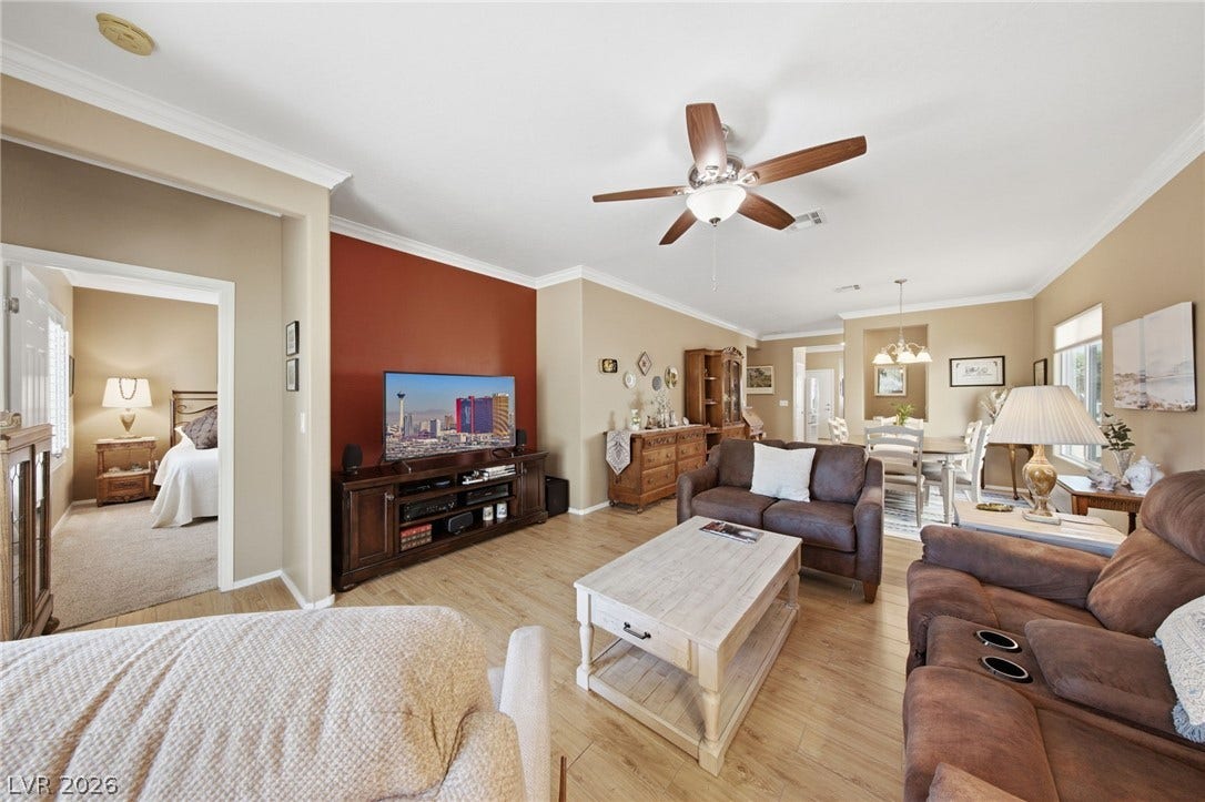7340 Shelduck Street, North Las Vegas, NV 89084 Warm wood flooring and elegant crown molding define this open, airy living space.