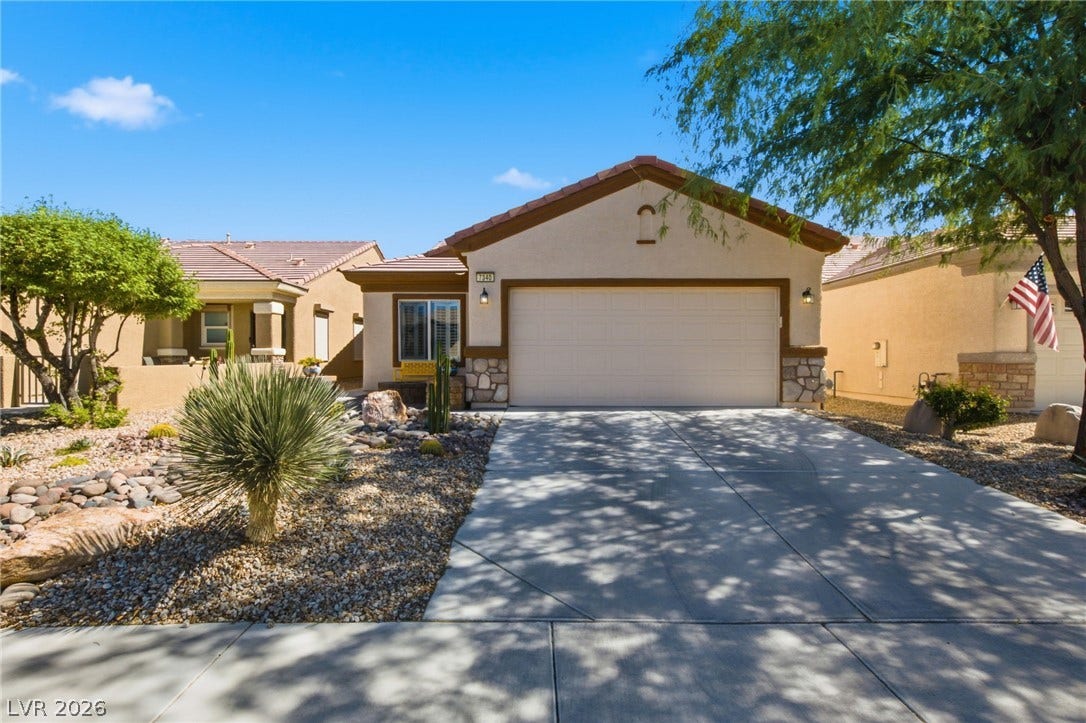 7340 Shelduck Street, North Las Vegas, NV 89084 An inviting stucco exterior features a concrete driveway leading to a two-car garage.
