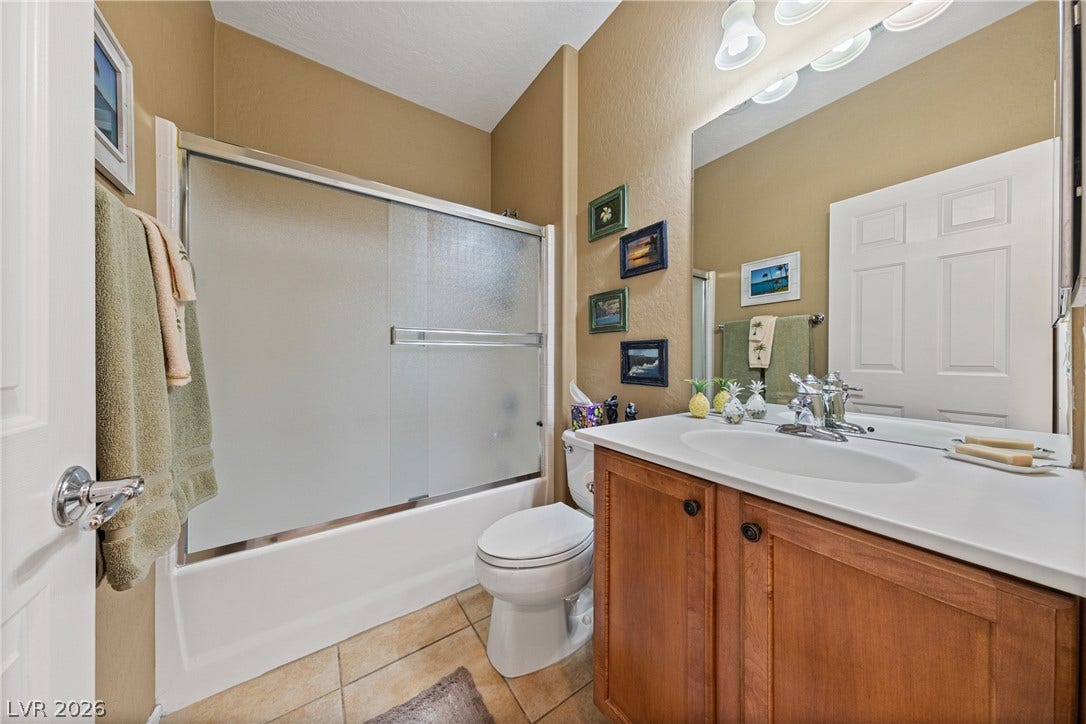 7340 Shelduck Street, North Las Vegas, NV 89084 Warm wood cabinetry and tile flooring anchor this functional guest bathroom.