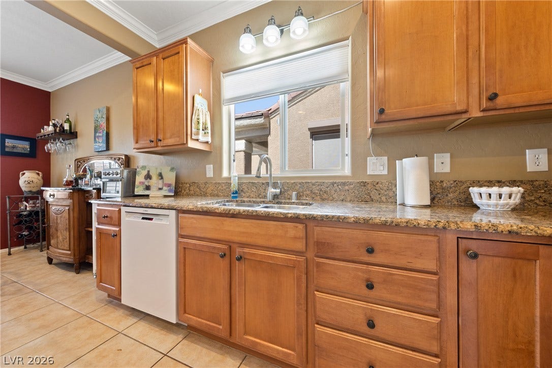 7340 Shelduck Street, North Las Vegas, NV 89084 Rich wood cabinetry and expansive granite countertops define this classic, functional kitchen workspace.