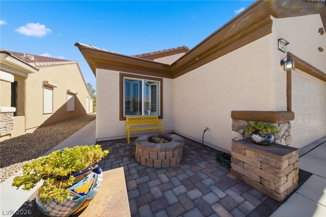7340 Shelduck Street, North Las Vegas, NV 89084 An inviting paver courtyard greets visitors alongside the stucco exterior and stone-accented garage details.
