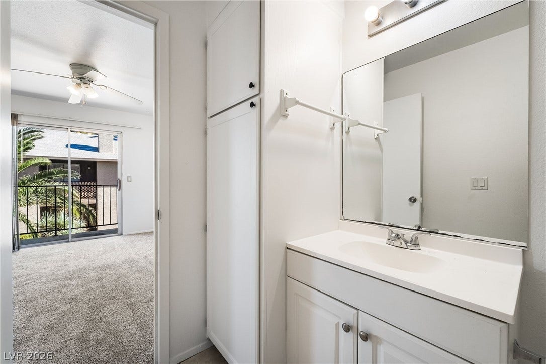 535 Sellers Place, Henderson, NV 89011 Functional vanity area opens directly to a carpeted bedroom with outdoor balcony access.