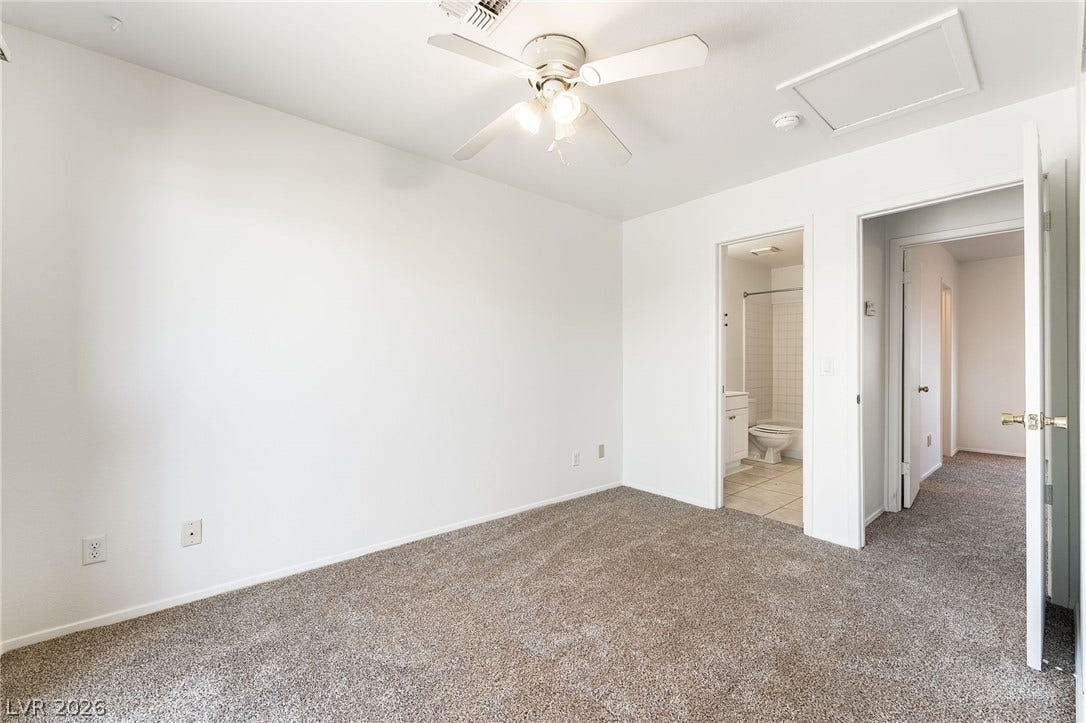 535 Sellers Place, Henderson, NV 89011 Plush carpeting and crisp white walls define this comfortable bedroom with an adjacent bath.