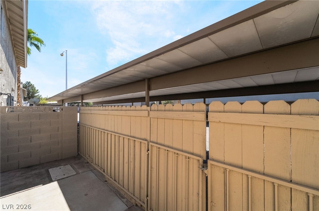 535 Sellers Place, Henderson, NV 89011 An enclosed concrete patio area features a sturdy privacy fence alongside covered carport parking.