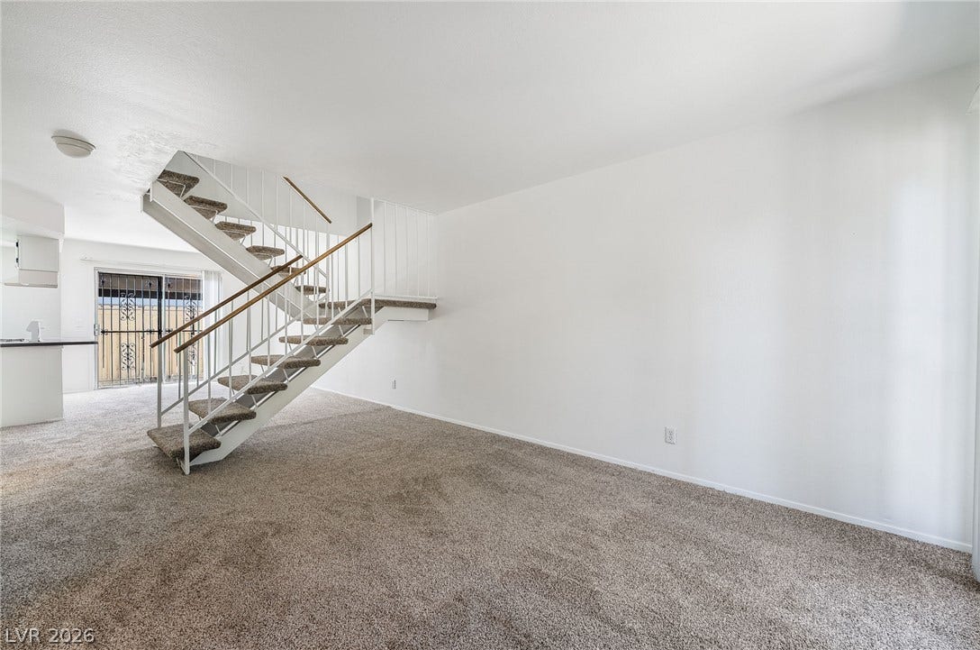 535 Sellers Place, Henderson, NV 89011 A spacious carpeted living area features a central open staircase leading to the upper level.