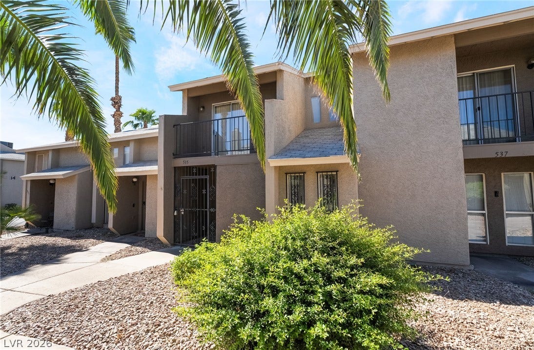 535 Sellers Place, Henderson, NV 89011 Palm trees frame the stucco exterior of this multi-level residential building.