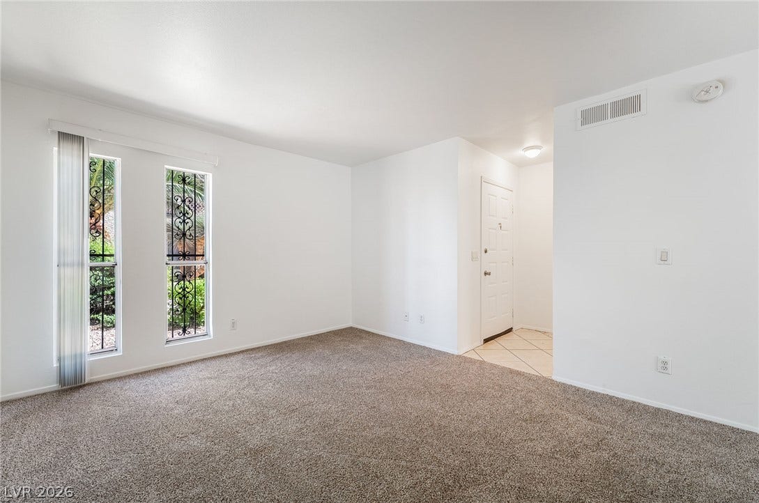 535 Sellers Place, Henderson, NV 89011 Plush carpeting and tall windows define this open living space adjacent to the tiled foyer.