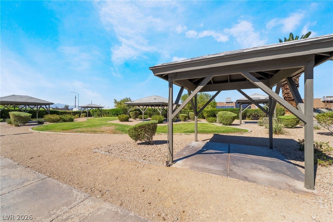535 Sellers Place, Henderson, NV 89011 Several wooden gazebos populate a landscaped outdoor space with gravel paths and green lawns.