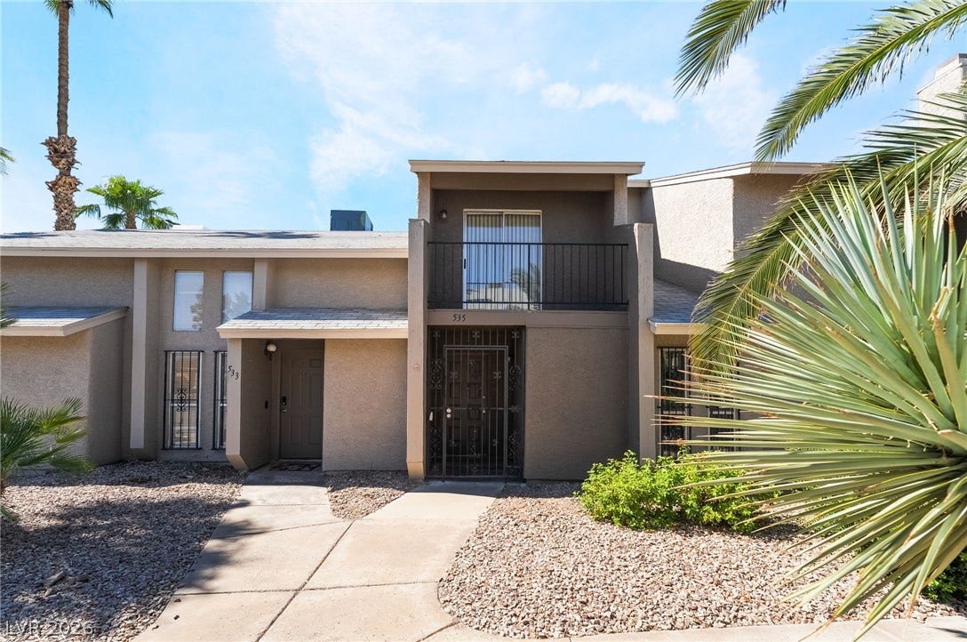 535 Sellers Place, Henderson, NV 89011 Mature palms and low-maintenance desert landscaping frame the stucco exterior and private upper-level balcony.
