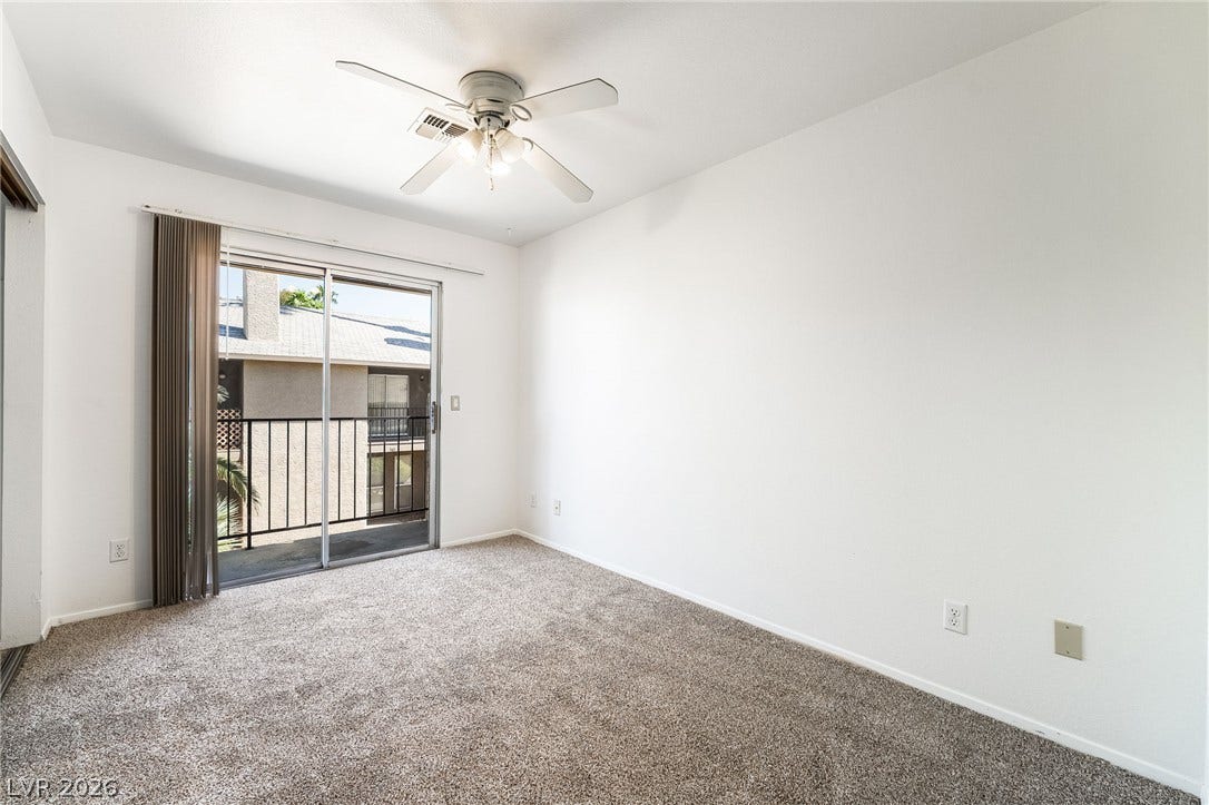 535 Sellers Place, Henderson, NV 89011 Sliding glass doors open directly to a private balcony from this carpeted bedroom.