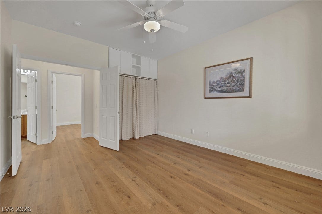 625 Bighorn Creek Street, Henderson, NV 89002 Warm wood flooring and classic crown molding anchor this versatile, airy bedroom space.