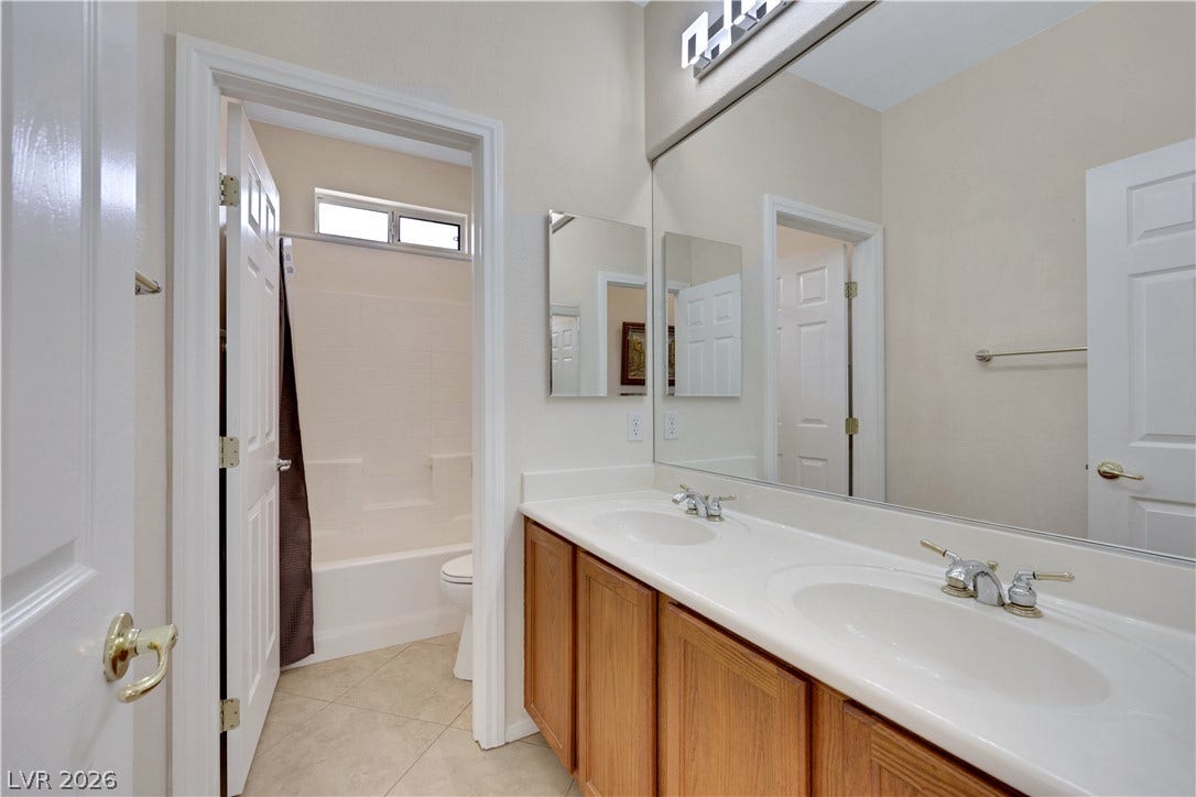 625 Bighorn Creek Street, Henderson, NV 89002 Double vanity offers ample space for morning routines, complemented by a large mirror and bright overhead lighting.