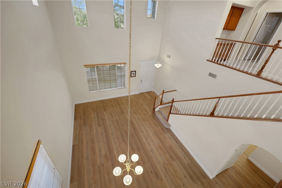 625 Bighorn Creek Street, Henderson, NV 89002 High ceilings and a towering wall of windows illuminate the wood-look flooring below.