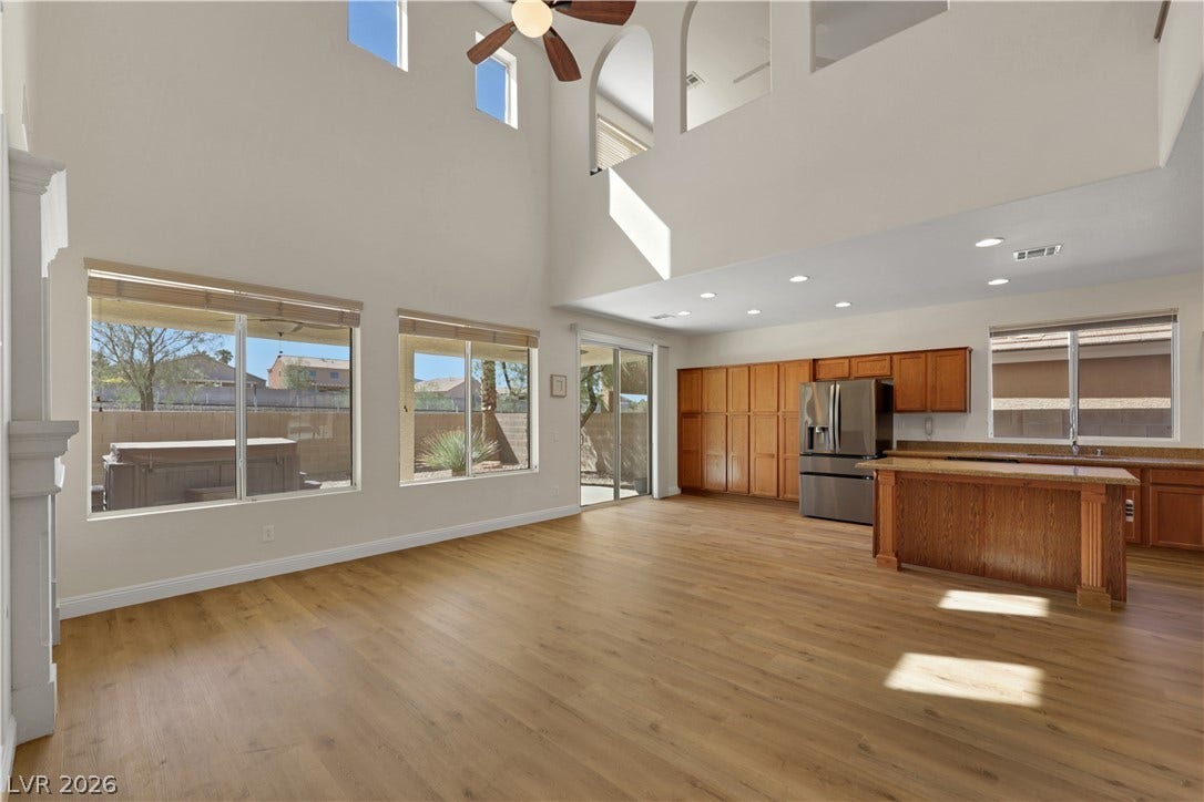 625 Bighorn Creek Street, Henderson, NV 89002 Double-height ceilings and rich wood floors anchor this open-concept main-level living space.