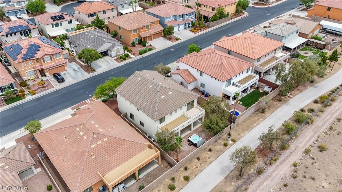625 Bighorn Creek Street, Henderson, NV 89002 An aerial perspective reveals a vibrant neighborhood with diverse rooflines and solar panels on select homes.