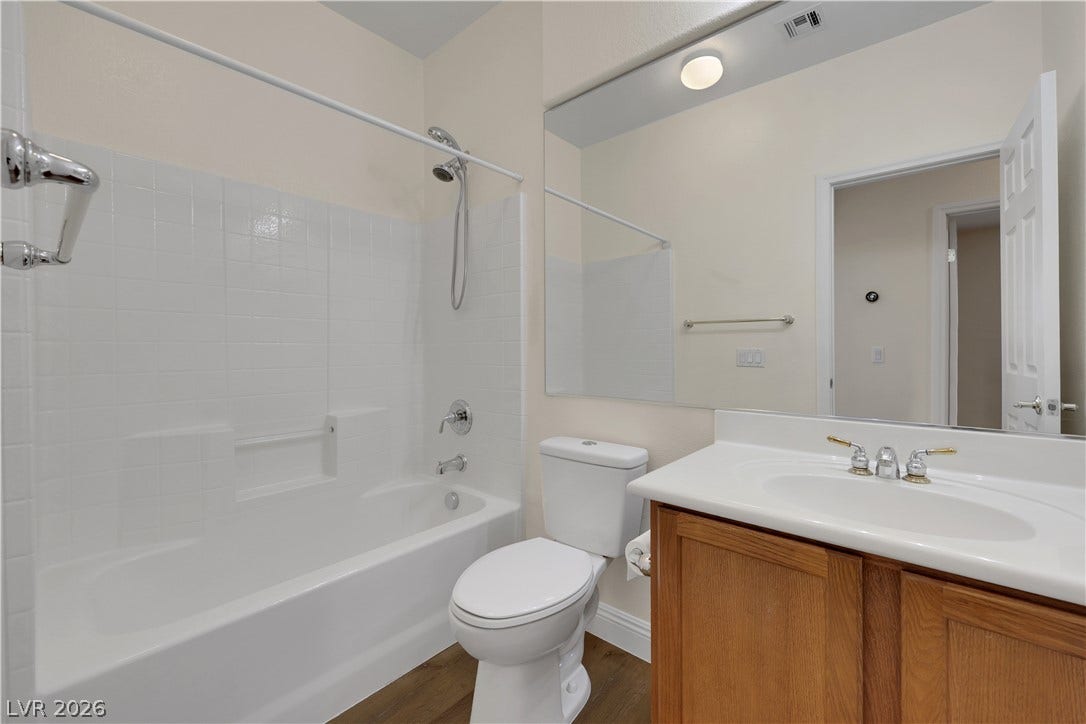 625 Bighorn Creek Street, Henderson, NV 89002 A classic bathroom featuring a wood vanity, recessed mirror, and integrated tub and shower unit.