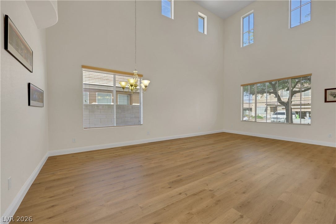 625 Bighorn Creek Street, Henderson, NV 89002 Double-height ceilings and rich wood-style flooring anchor this airy living space.