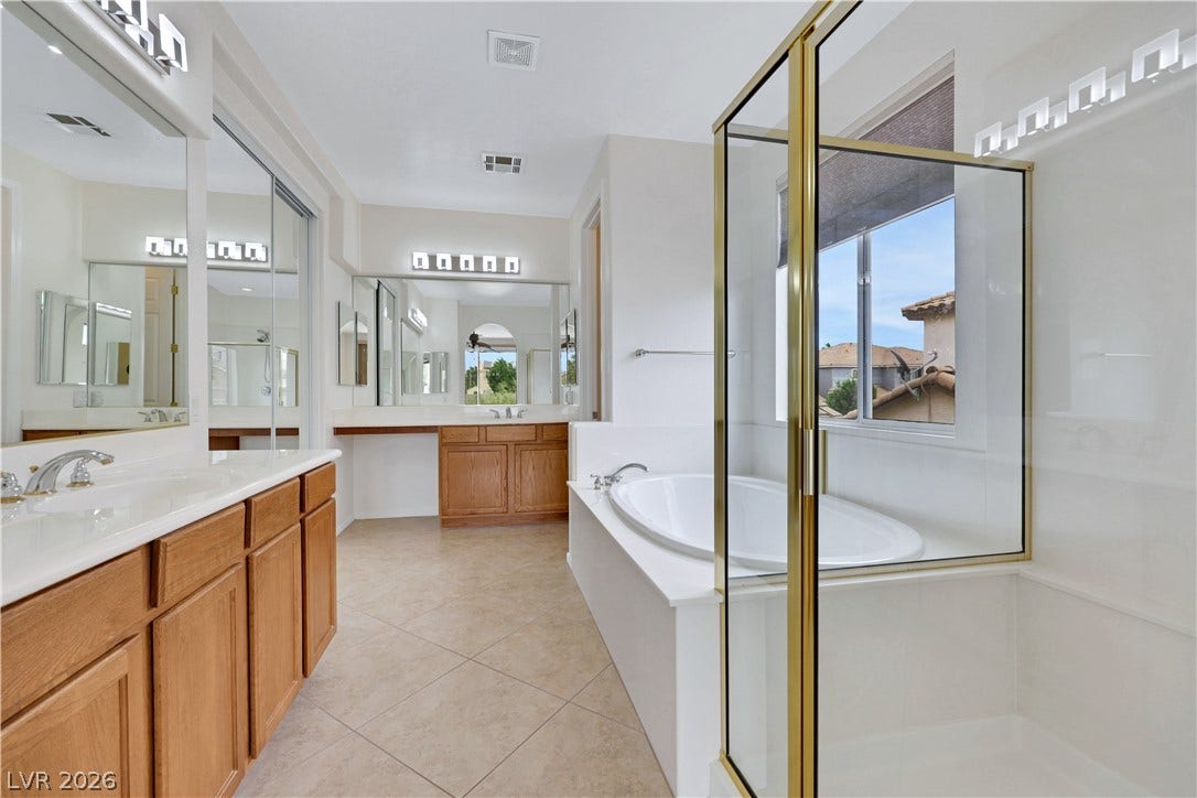 625 Bighorn Creek Street, Henderson, NV 89002 Indulge in a primary bathroom featuring a spacious walk-in shower and a separate soaking tub.