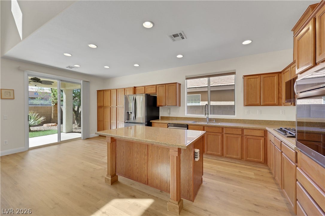 625 Bighorn Creek Street, Henderson, NV 89002 Gleaming wood floors anchor a well-appointed kitchen showcasing a central island and recessed lighting.