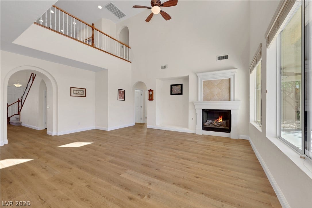 625 Bighorn Creek Street, Henderson, NV 89002 Soaring ceilings and warm wood floors frame a grand fireplace in this open living space.