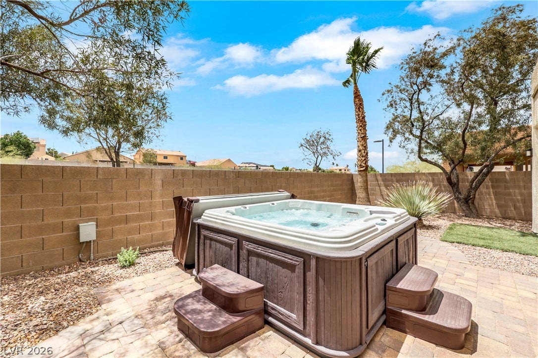 625 Bighorn Creek Street, Henderson, NV 89002 An inviting backyard spa with stone pavers offers tranquil relaxation under the open sky.