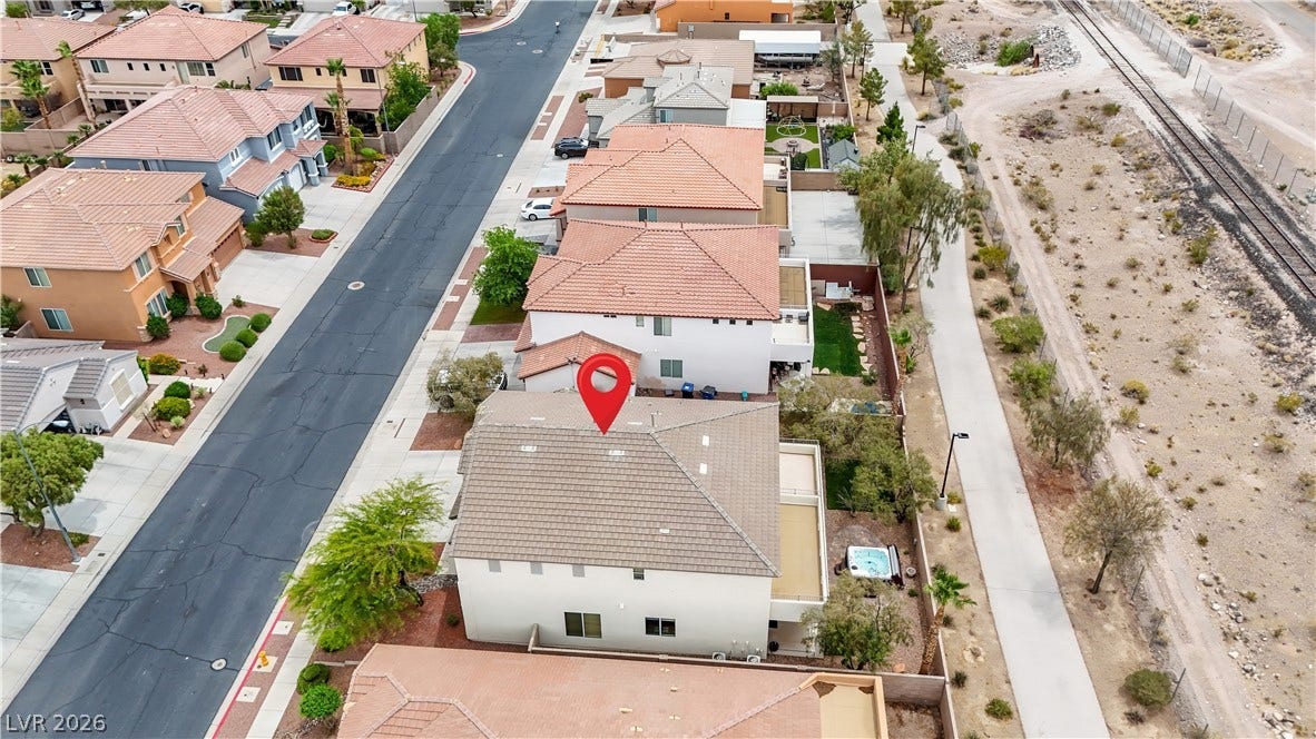 625 Bighorn Creek Street, Henderson, NV 89002 An aerial perspective showcases a residential neighborhood with a private spa and convenient rail line proximity.