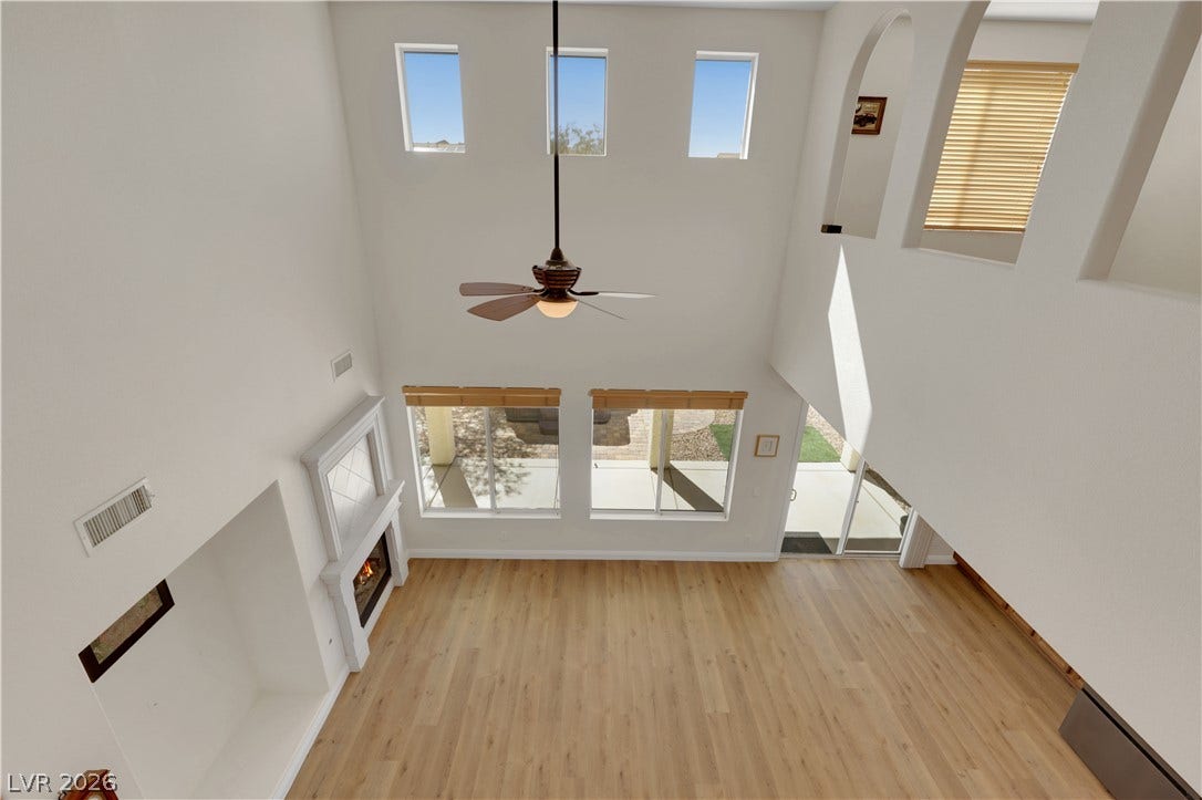 625 Bighorn Creek Street, Henderson, NV 89002 Towering ceilings and light-toned wood flooring anchor this airy, light-filled living area.