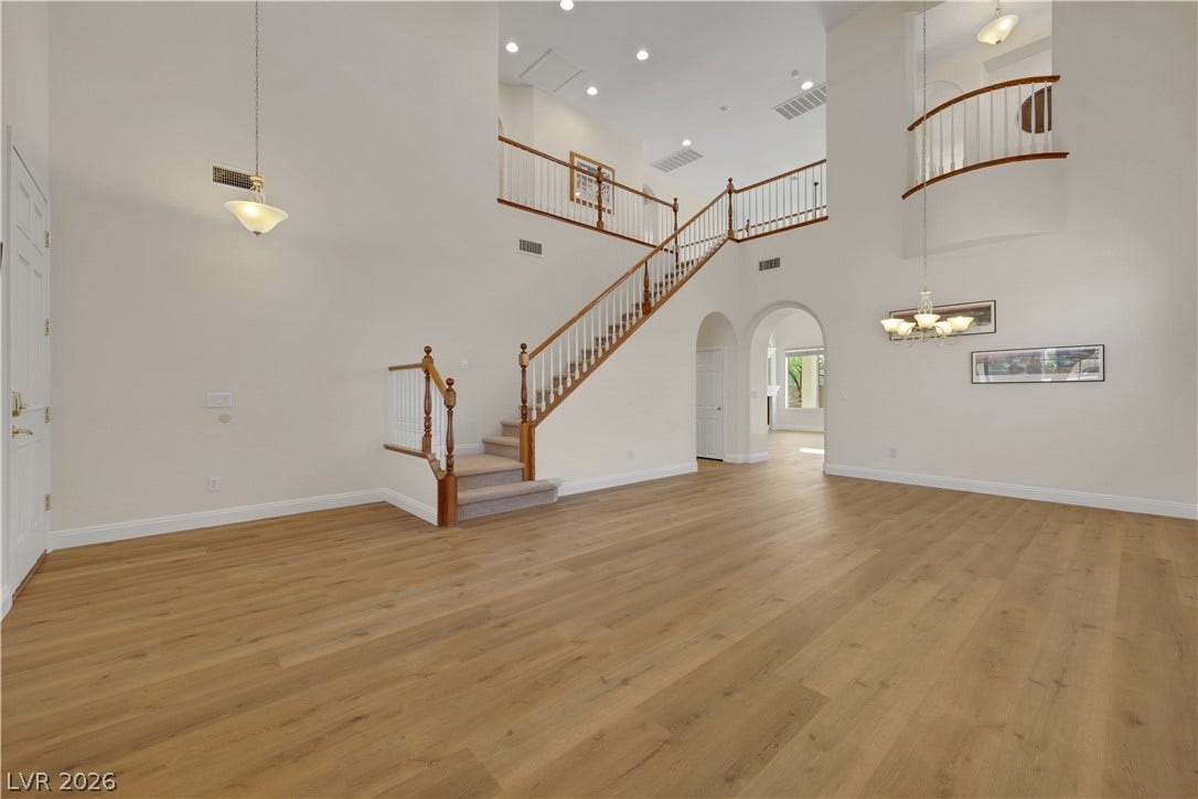 625 Bighorn Creek Street, Henderson, NV 89002 An elegant staircase ascends from the warm wood-floored living area beneath soaring ceilings.