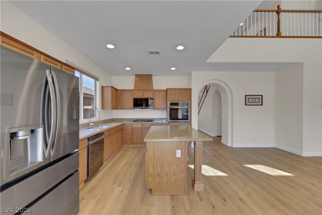 625 Bighorn Creek Street, Henderson, NV 89002 Warm wood cabinetry and a central island ground this open-plan kitchen with rich hardwood floors.
